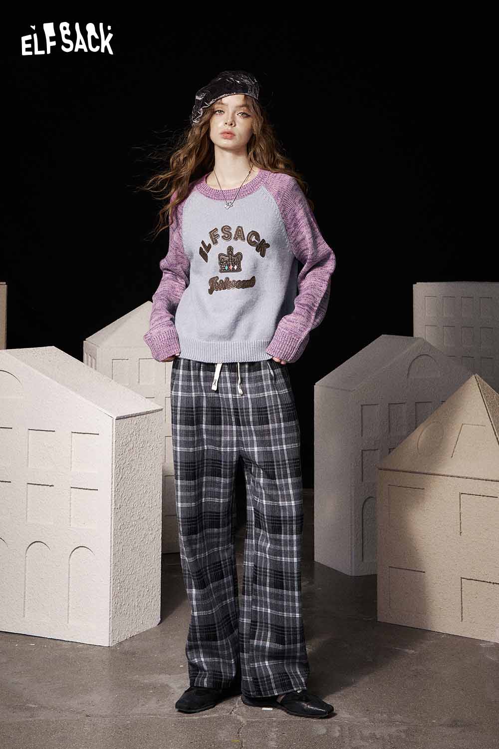 ELFSACK soft graphic knit sweater in gray and purple with stylish lettering, paired with plaid pants