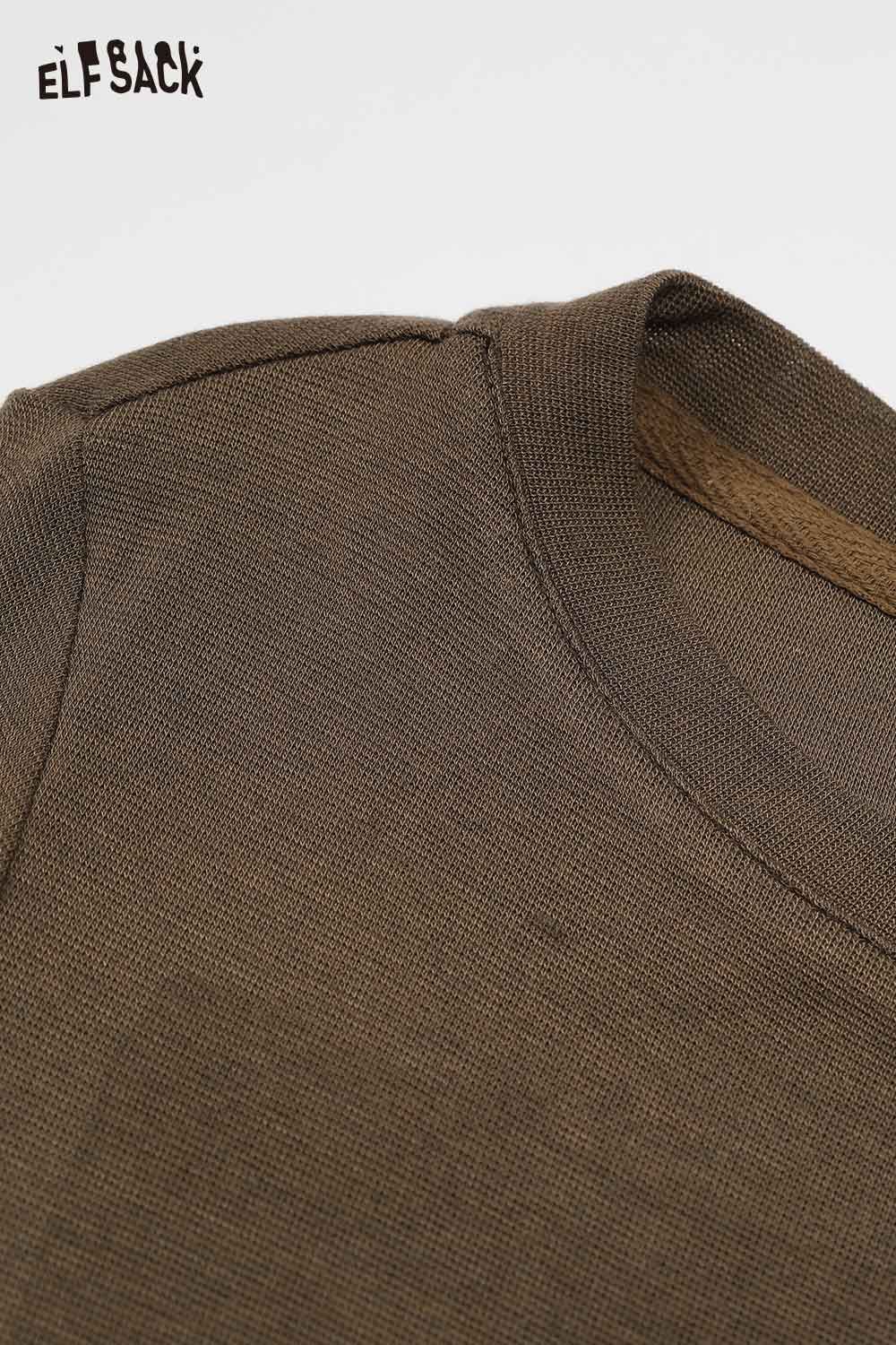 Close-up of ELFSACK embroidered fitted long sleeve tee in earth tone fabric with a smooth neckline