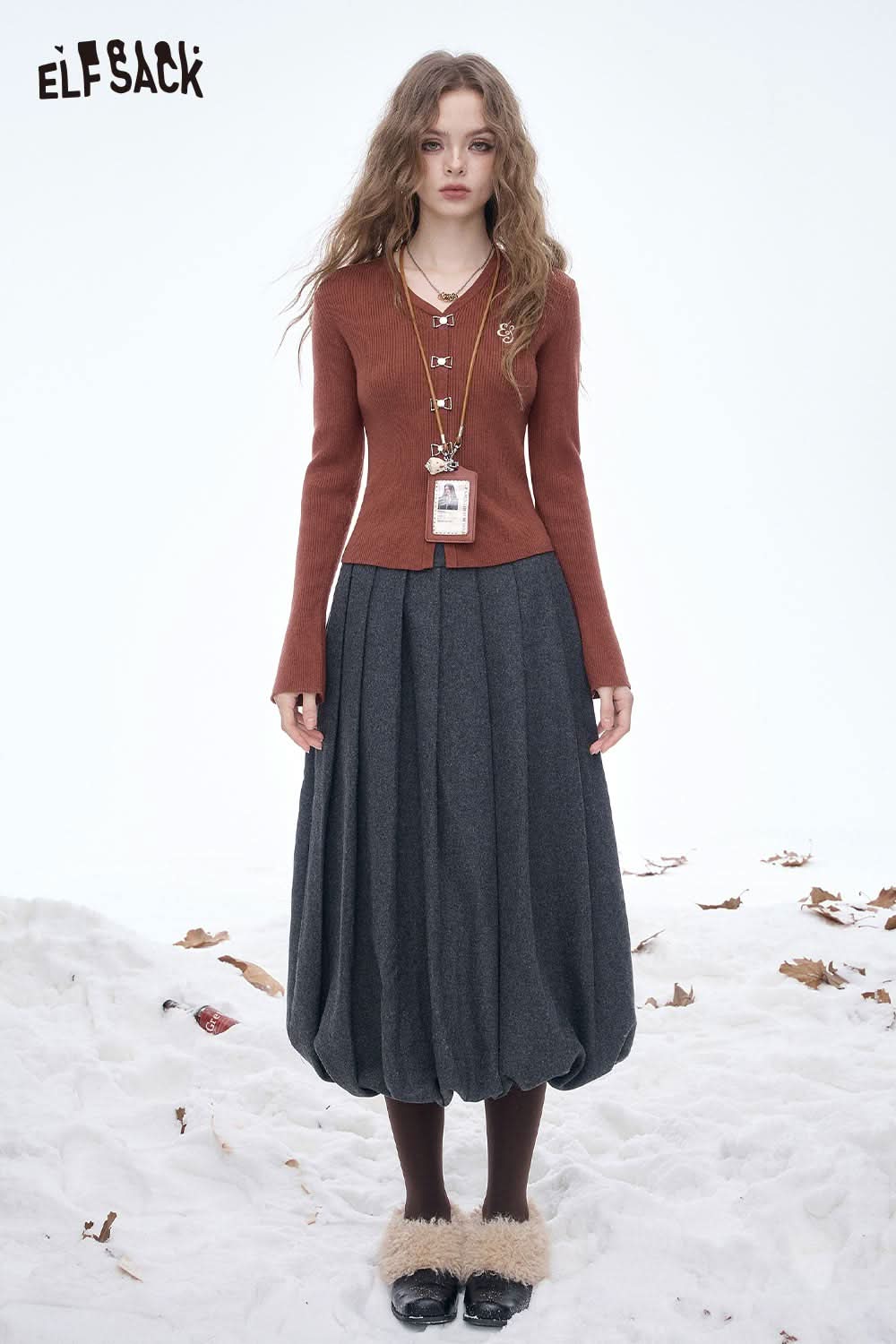 ELFSACK embroidered knit V neck sweater in rust color paired with a gray pleated skirt