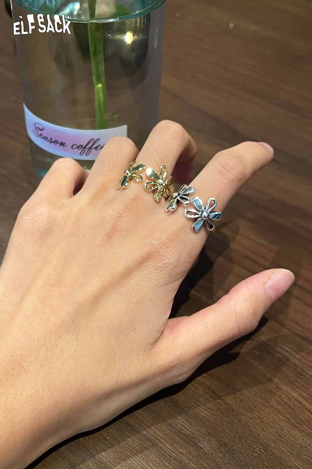 ELFSACK floral copper statement ring displayed on a hand with a stylish design and multiple flower motifs