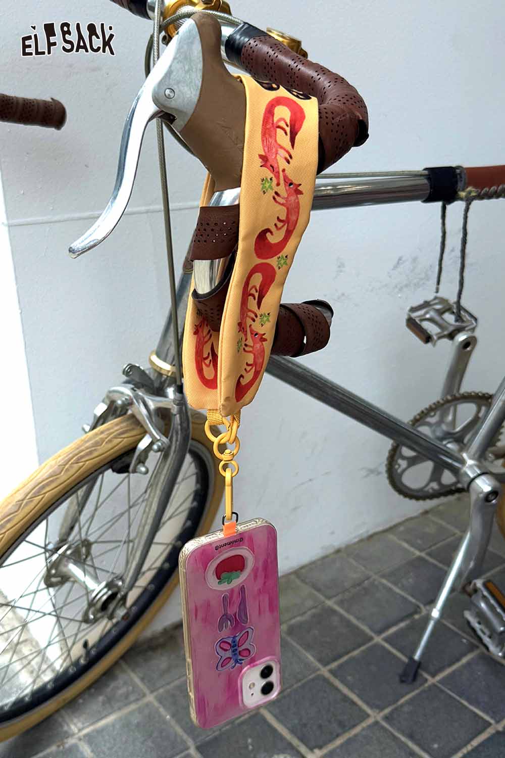 ELFSACK fox character phone strap hanging from a bicycle handlebar for stylish accessory lovers