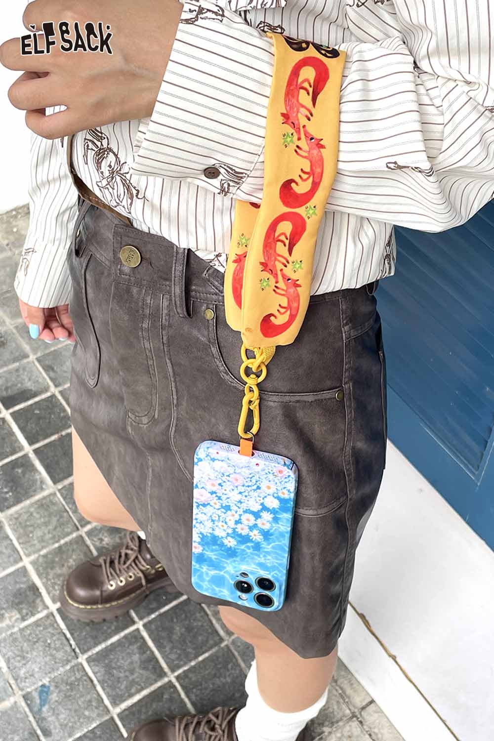 ELFSACK fox character phone strap attached to a floral phone case for a stylish look