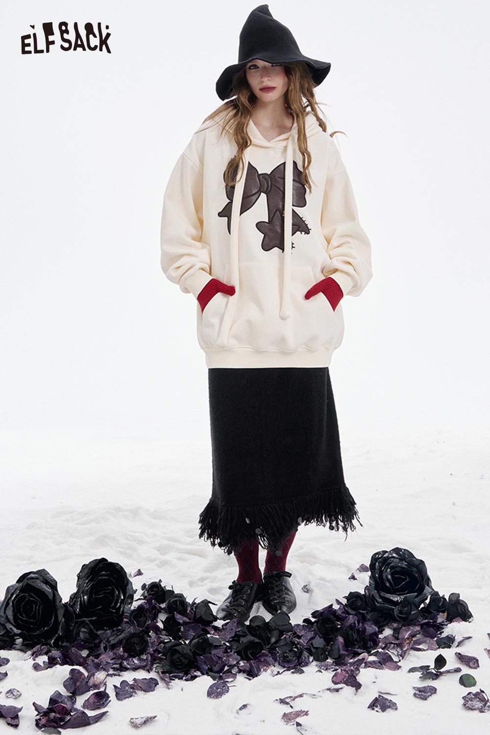 ELFSACK fringe hem long skirt styled with a cozy hoodie and surrounded by black roses