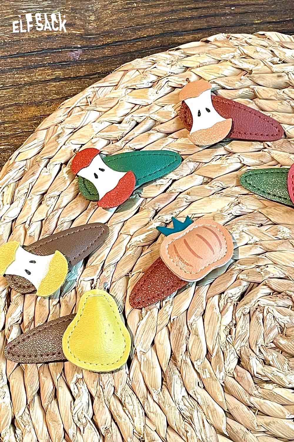 Colorful genuine leather fruit hairpin set featuring various fruit designs on a natural woven mat