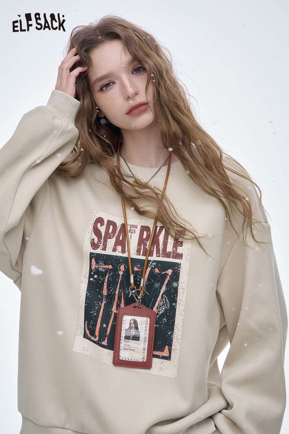 ELFSACK women's graphic sweatshirt in beige with a unique sparkle design and a trendy necklace