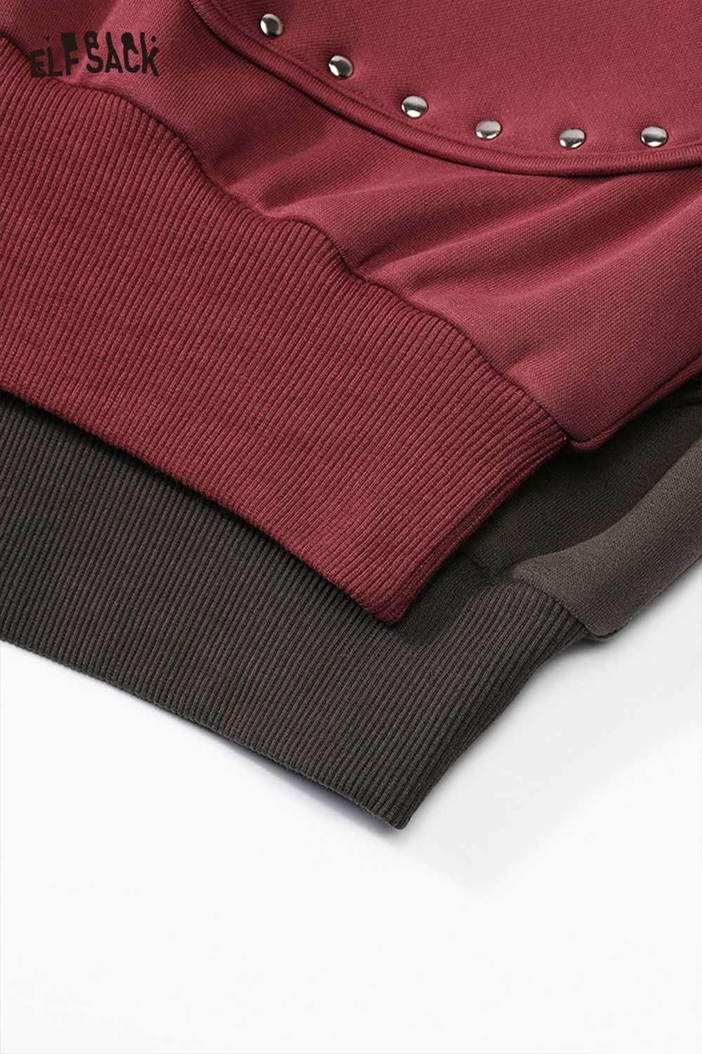 Close-up of ELFSACK heart patchwork hooded sweatshirt showing ribbed cuffs in burgundy and dark green