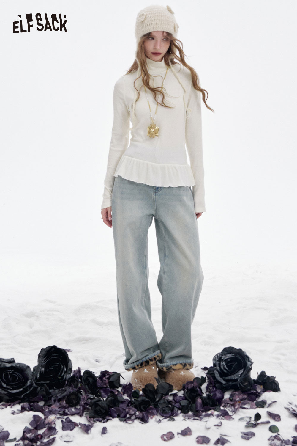 Stylish ELFSACK high neck flounce hem tshirt in white paired with loose jeans, surrounded by black roses