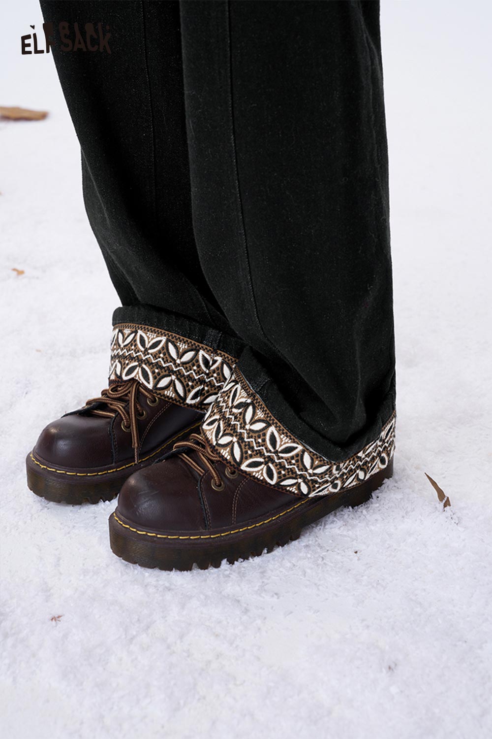 ELFSACK leaf print floor length jeans styled with decorative winter boots on a snowy surface