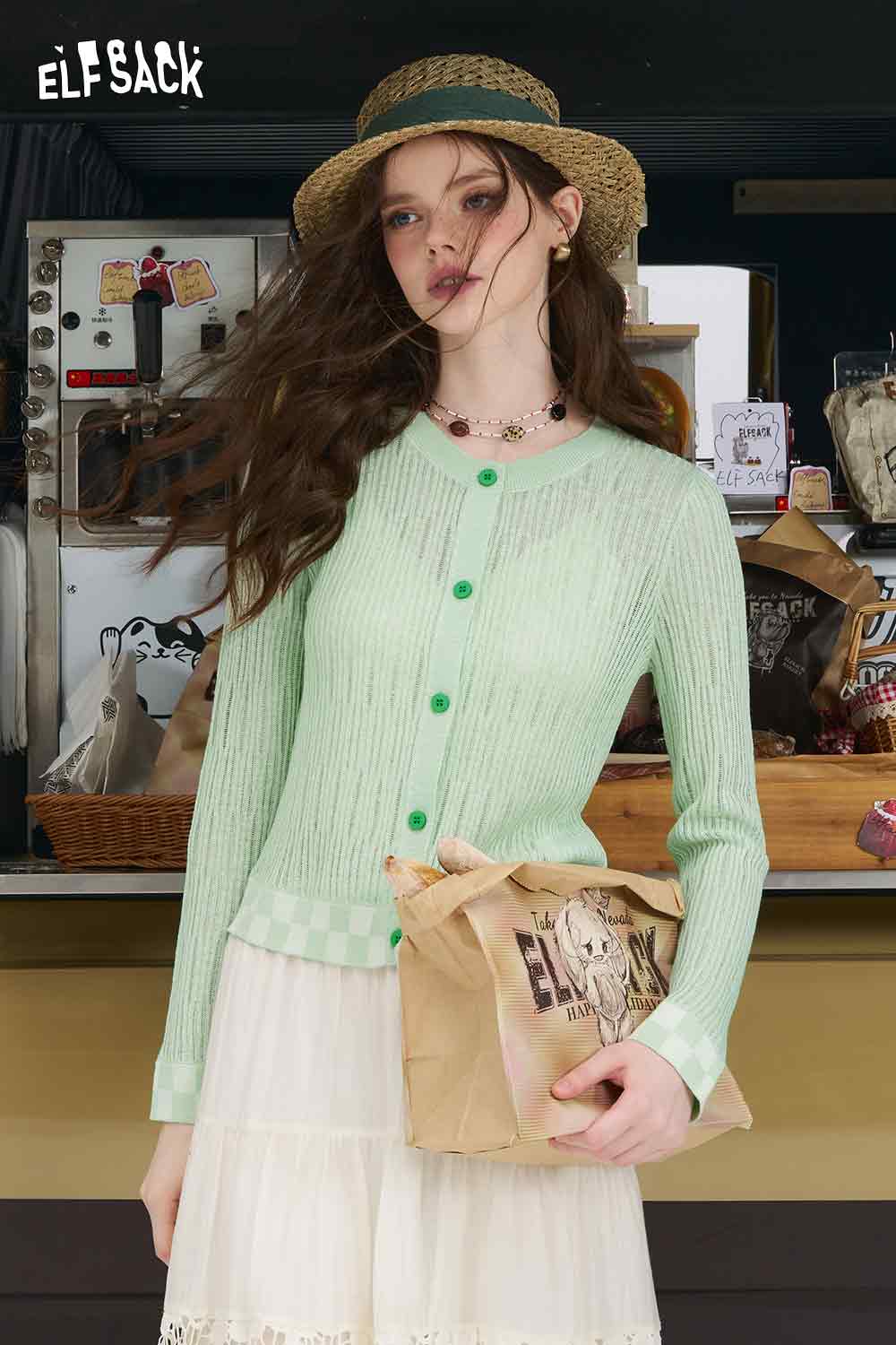 ELFSACK model wearing mint checkered knit cardigan with green buttons and check hem paired with white skirt