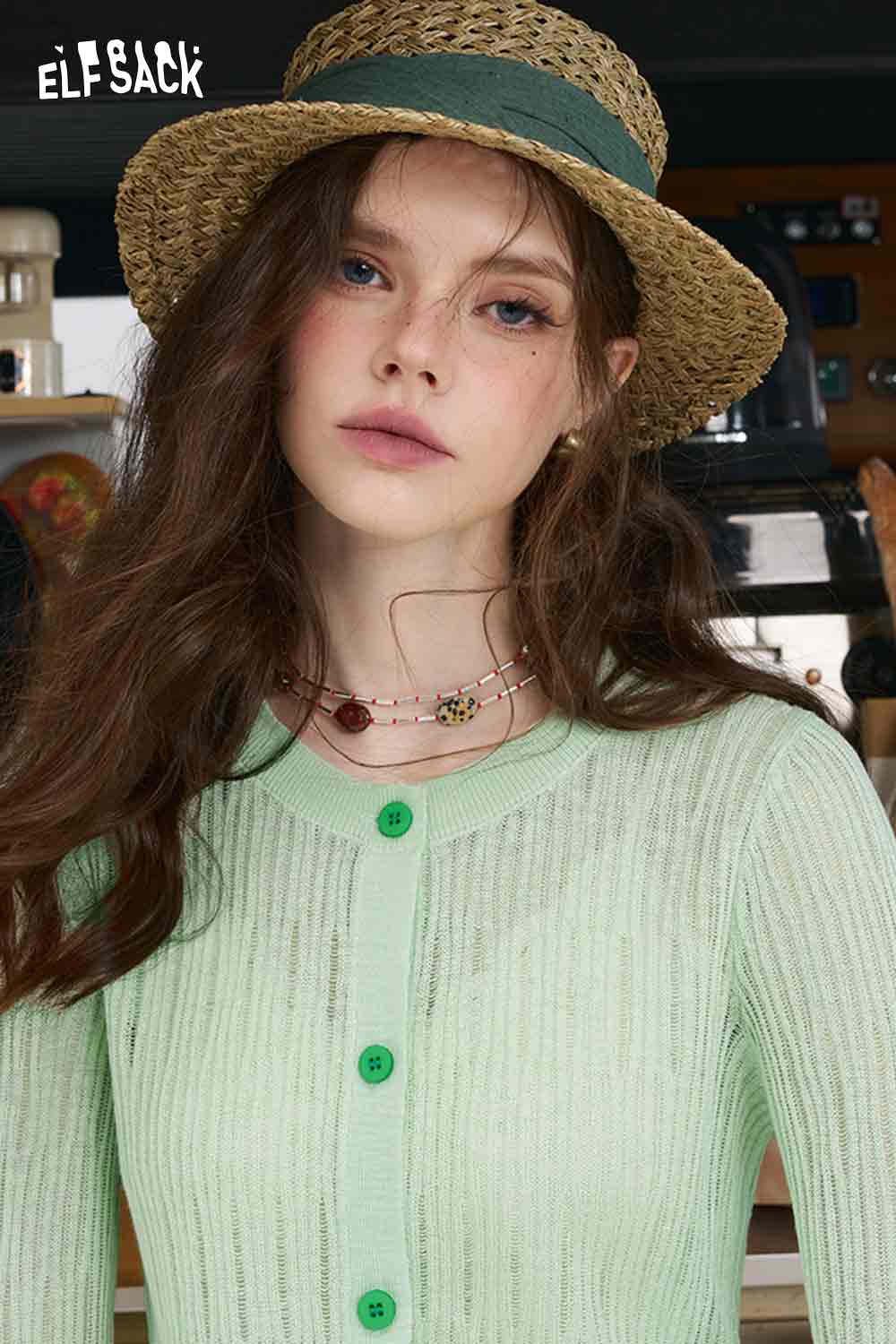 ELFSACK model wearing mint checkered knit cardigan with ribbed texture green buttons and straw hat