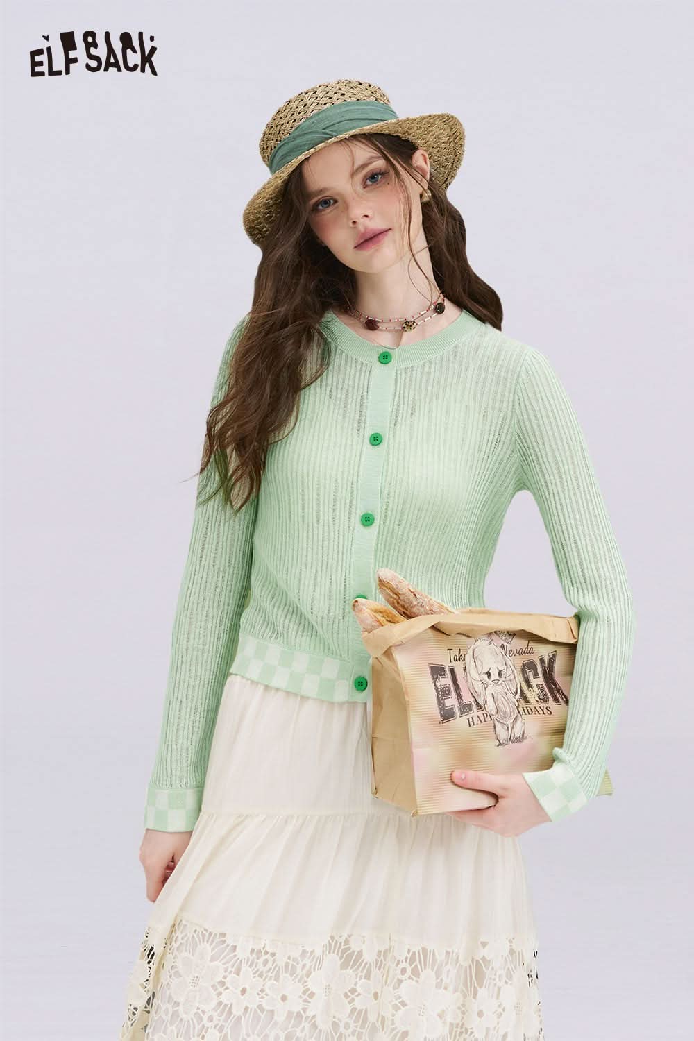 ELFSACK model wearing a mint checkered knit cardigan with green buttons straw hat and lace skirt