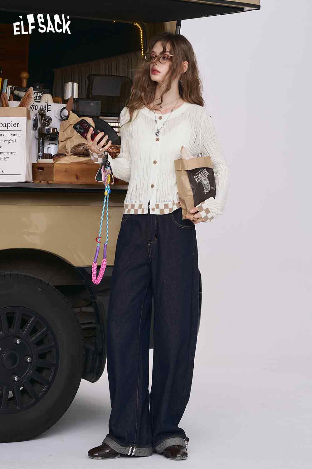 ELFSACK model wearing mint checkered knit cardigan with cream buttons paired with wide leg jeans by coffee truck