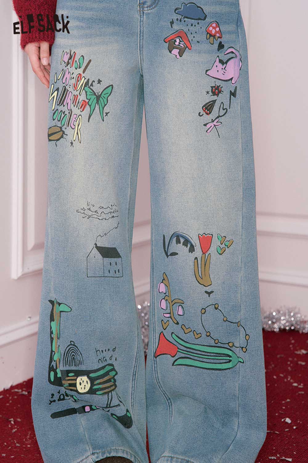 ELFSACK loose straight leg graphic jeans featuring colorful artistic designs on a light wash fabric