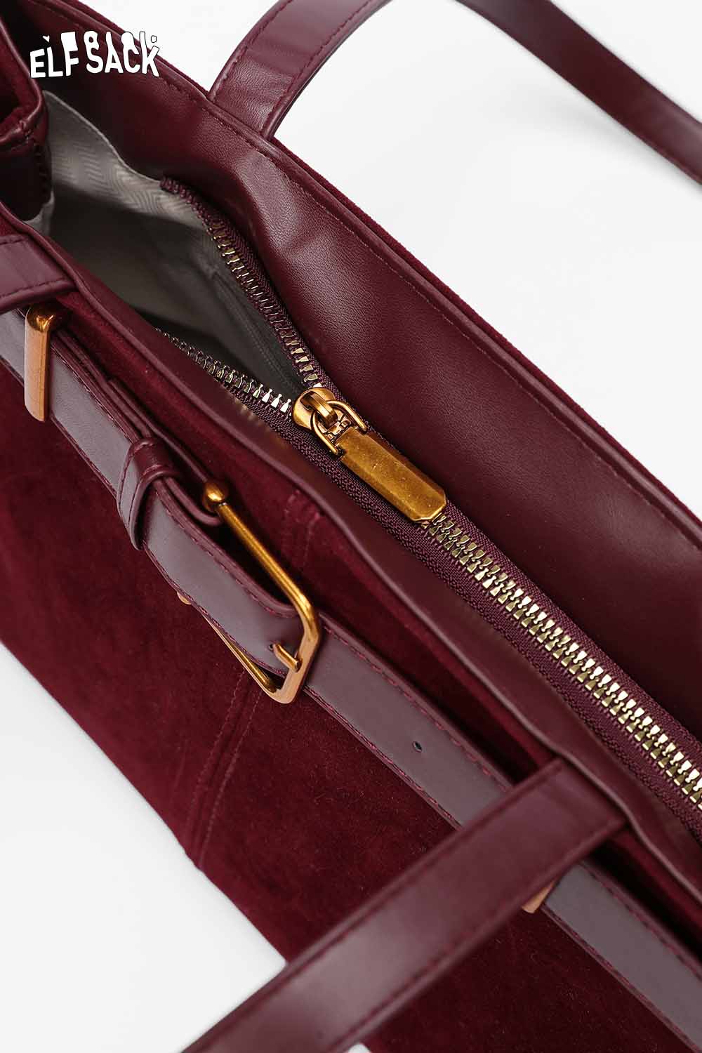 Elegant burgundy microsuede crossbody bag featuring a zippered main compartment and stylish hardware