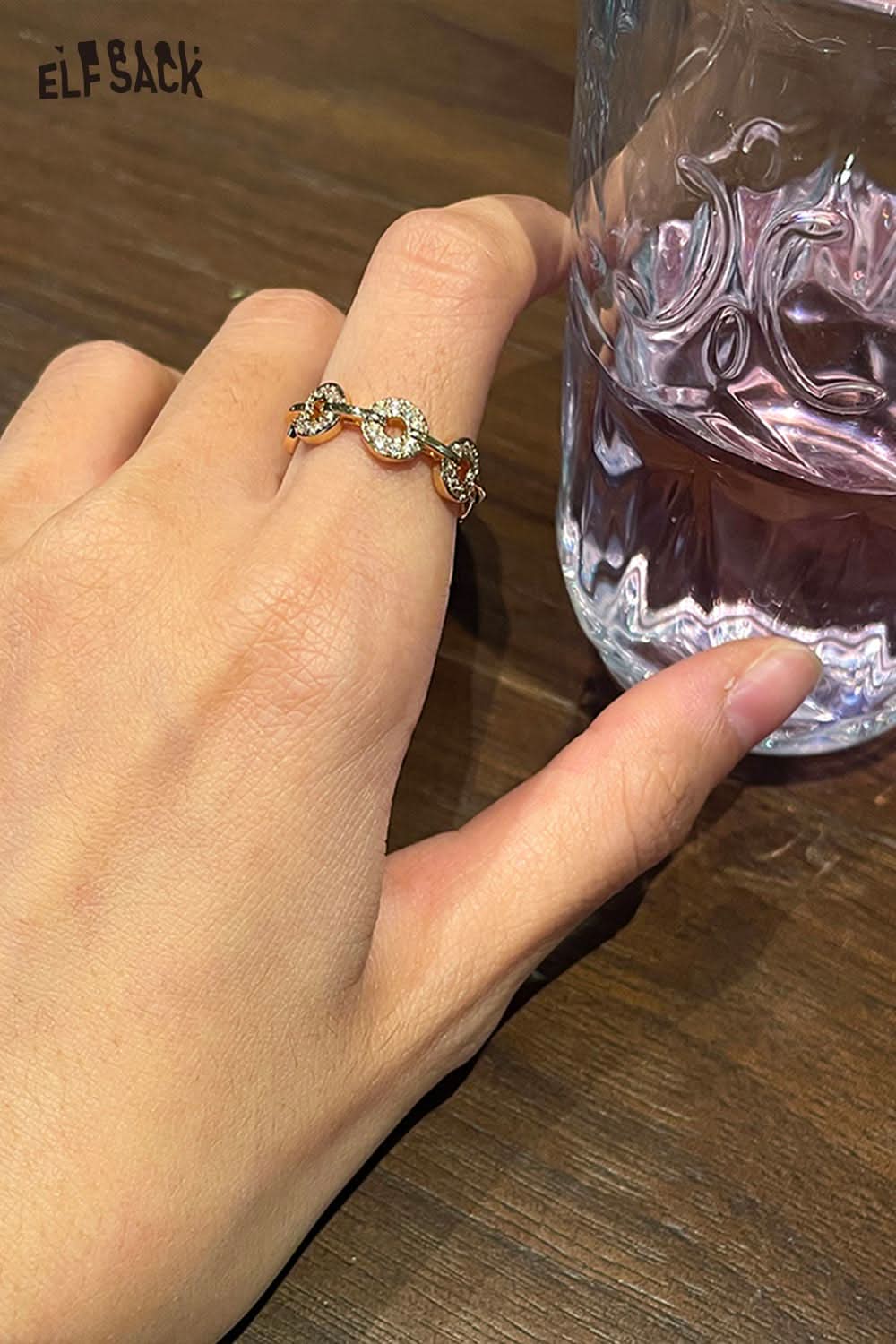 Elegant ELFSACK minimalist copper coin ring on a hand near a glass of water