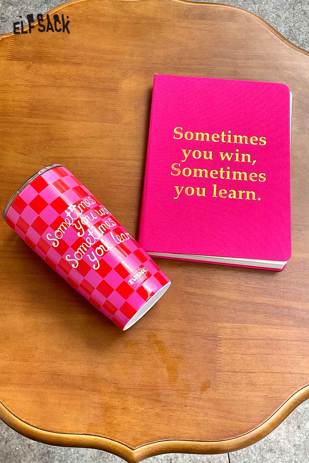 ELFSACK motivational quote hardcover notebook with a pink cover next to a matching tumbler