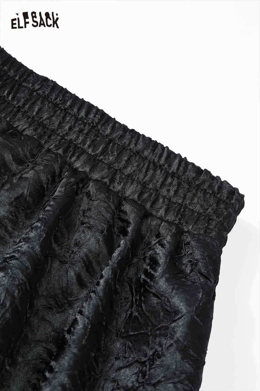Close-up of ELFSACK pleated A-line long skirt with elastic waistband detail in black