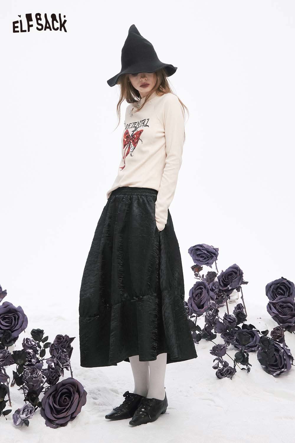 ELFSACK pleated A-line long skirt in black paired with a trendy top and hat