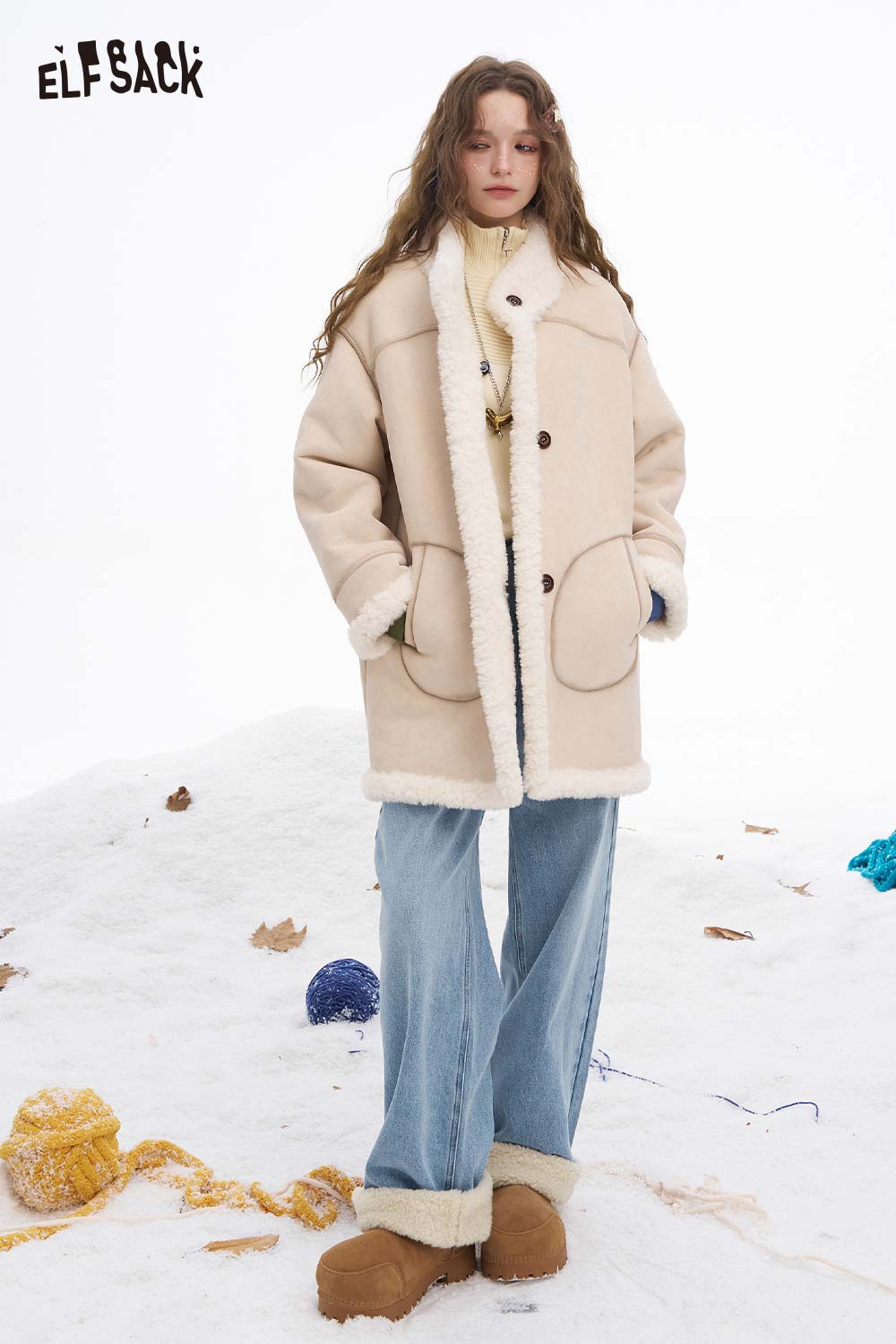 Woman wearing ELFSACK plush cuff straight jeans for women with a cozy jacket against a winter backdrop