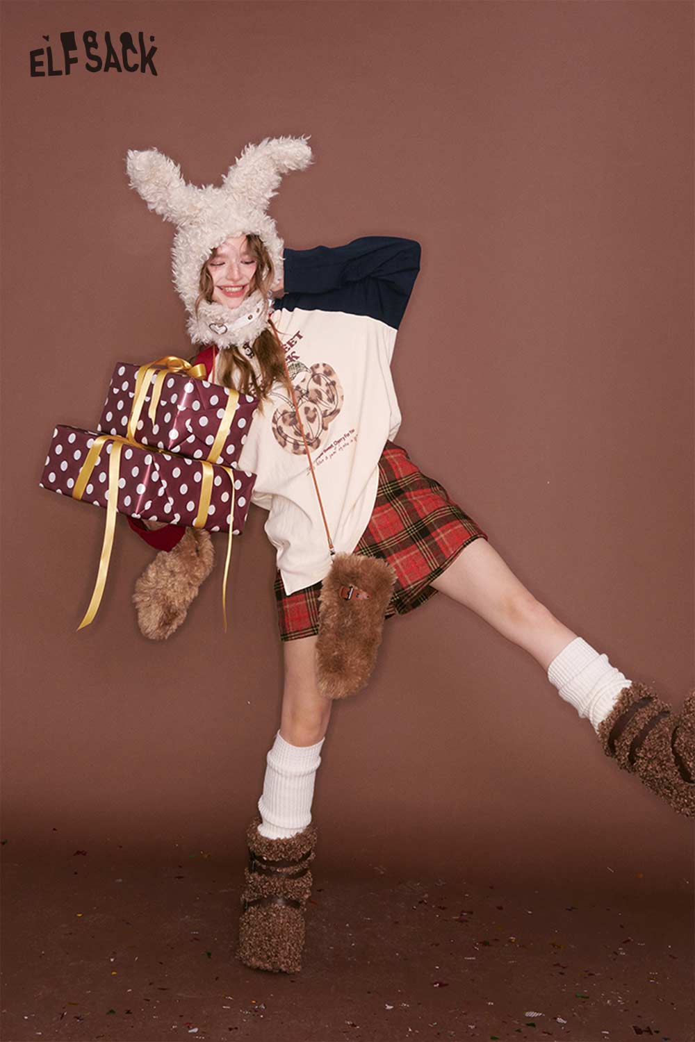 Model wearing ELFSACK preppy red plaid culottes skirt with a playful outfit and festive gifts