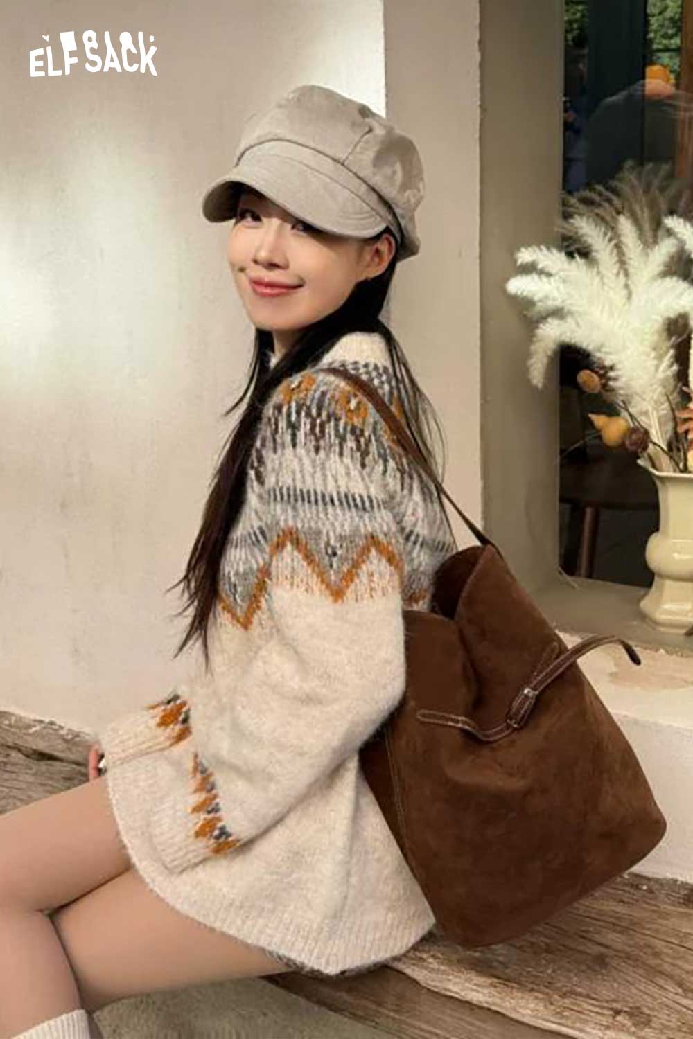 Woman wearing a cozy sweater with a PU leather bucket bag for women in a stylish setting