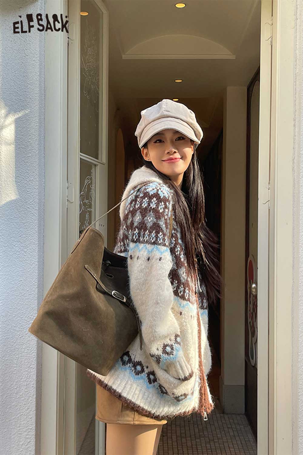 Stylish model wearing a cozy sweater and cap, carrying a PU leather bucket bag for women