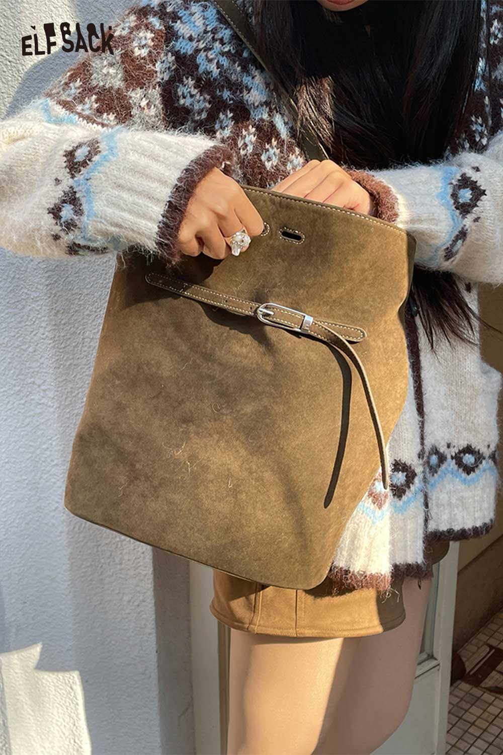 ELFSACK PU leather bucket bag for women held by a person wearing a stylish sweater