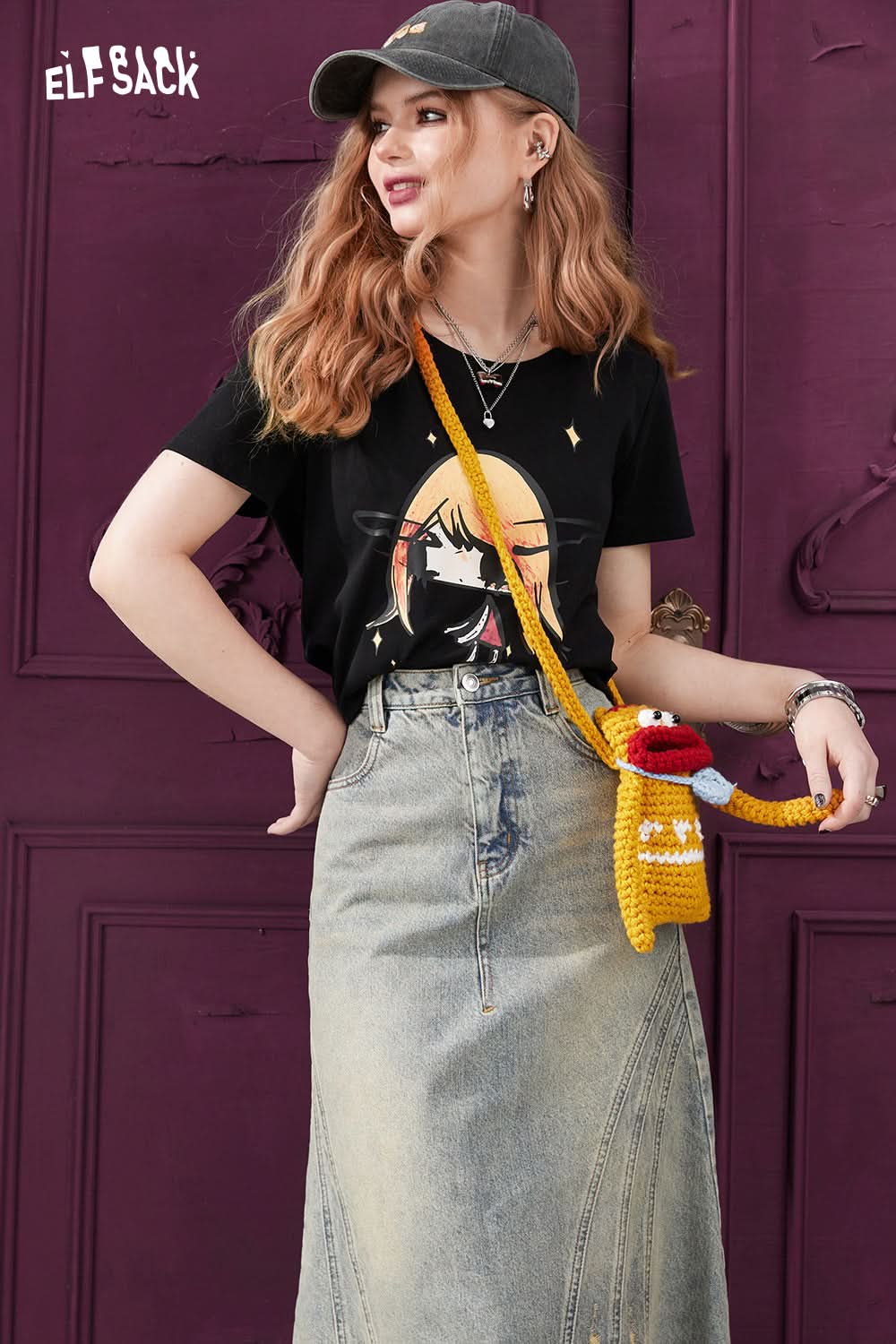 ELFSACK punk style black graphic T-shirt worn with denim skirt and crochet crossbody bag