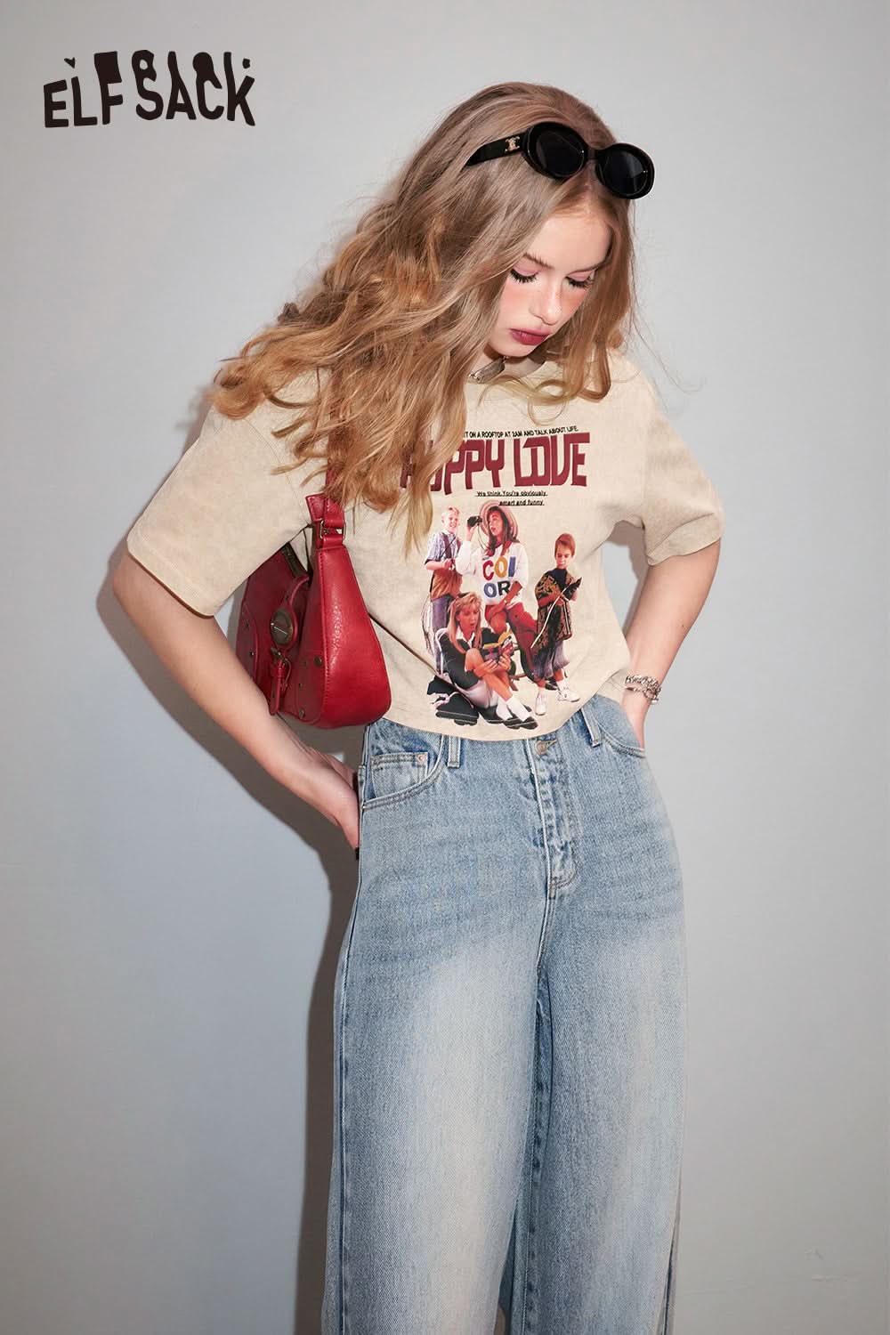 ELFSACK Retro Graphic beige T-shirt with vintage band print worn with light blue jeans and red shoulder bag