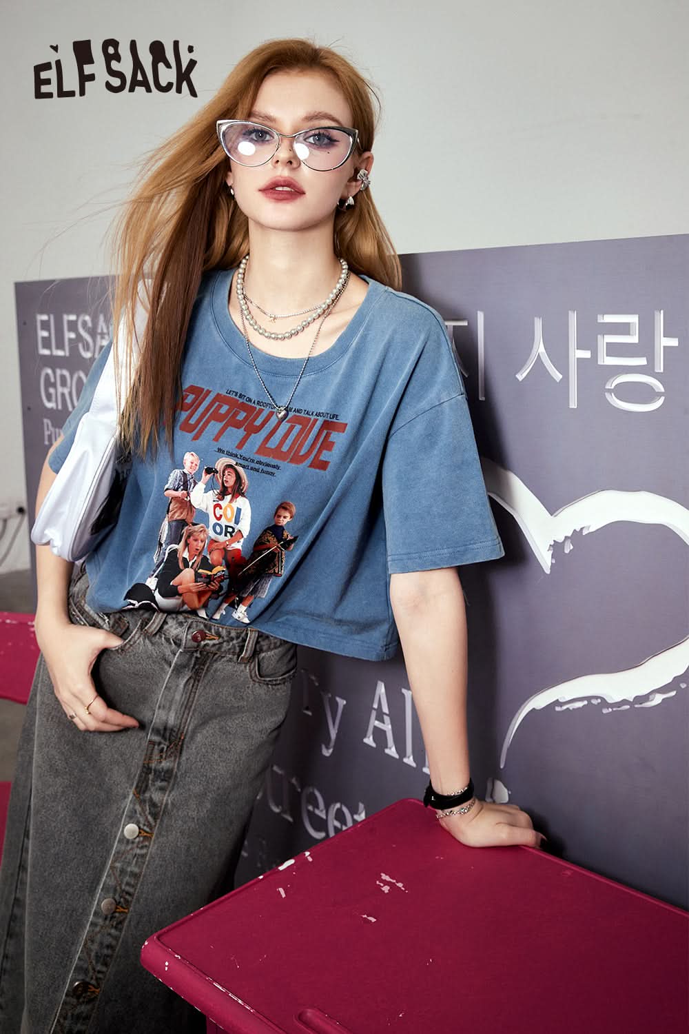 ELFSACK blue Retro Graphic T-shirt with colorful band print worn by woman with glasses