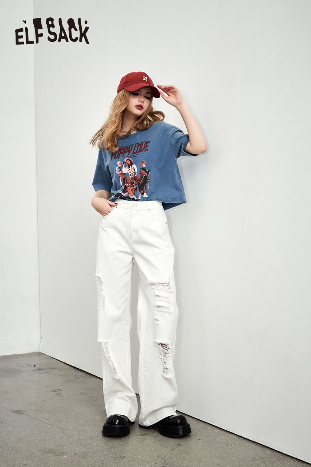 ELFSACK Retro Graphic blue cropped T-shirt styled with white ripped jeans and red cap