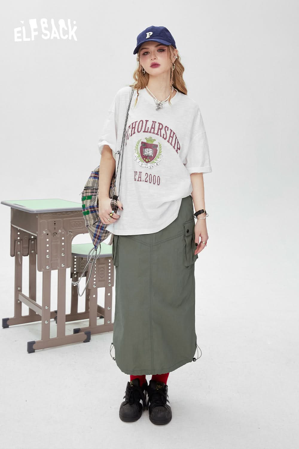ELFSACK white oversized t-shirt with red graphic print worn with green skirt and navy cap
