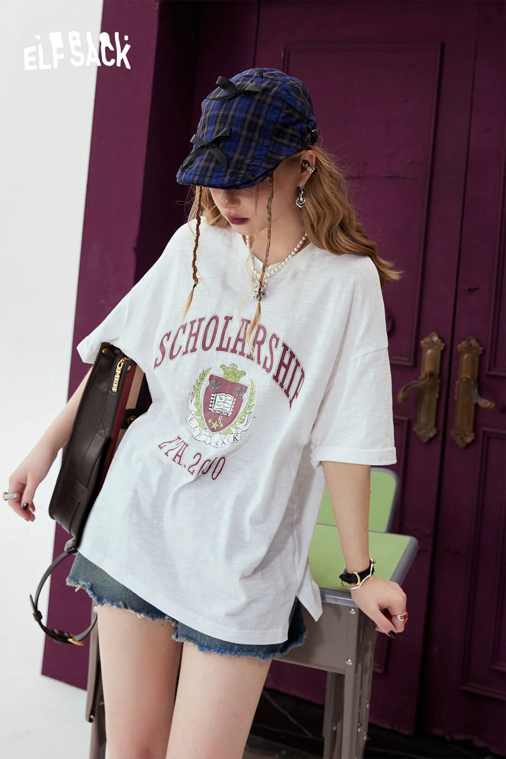 ELFSACK white oversized T-shirt with graphic print and scholarship design worn with denim shorts and a plaid cap