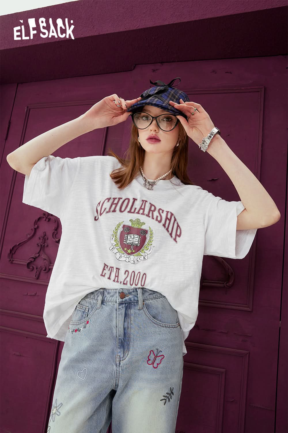 ELFSACK white oversized T-shirt with scholarship graphic print worn with high-waisted embroidered jeans