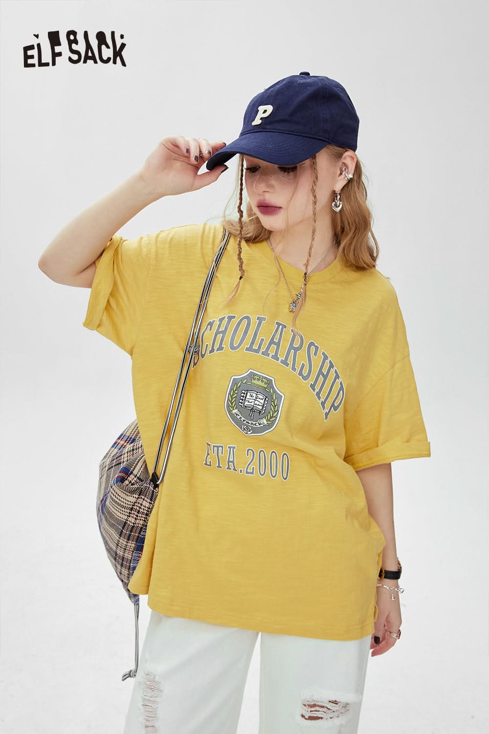 ELFSACK yellow graphic print t-shirt with scholarship design worn with blue cap and plaid bag