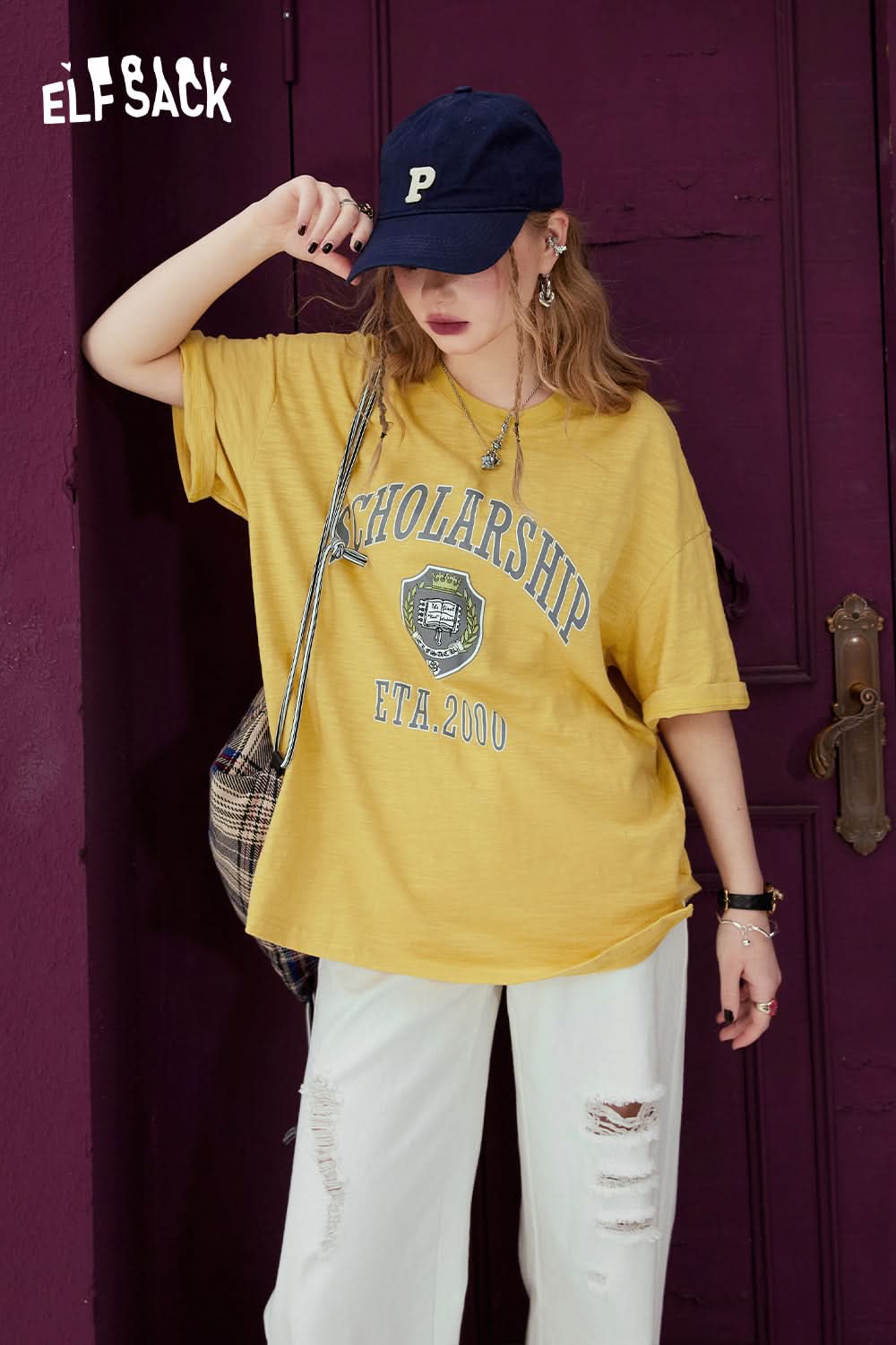 ELFSACK yellow graphic print t-shirt with scholarship text worn with white ripped pants and navy cap
