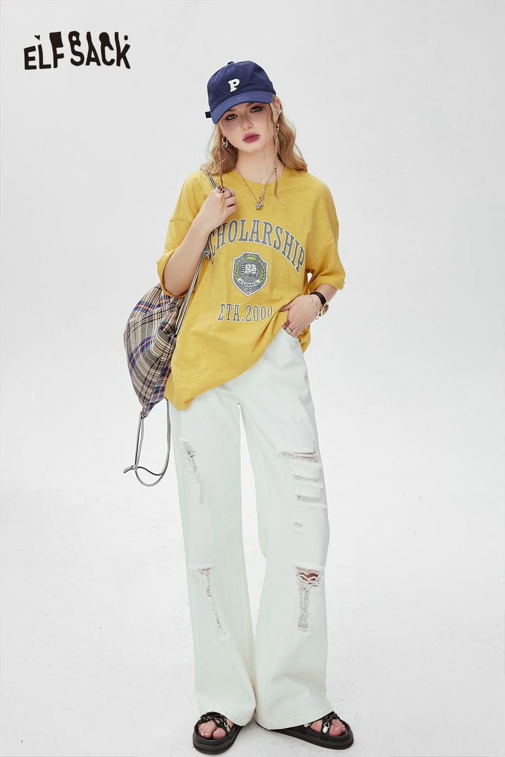 ELFSACK yellow graphic print t-shirt with scholarship design worn with white ripped pants and blue cap