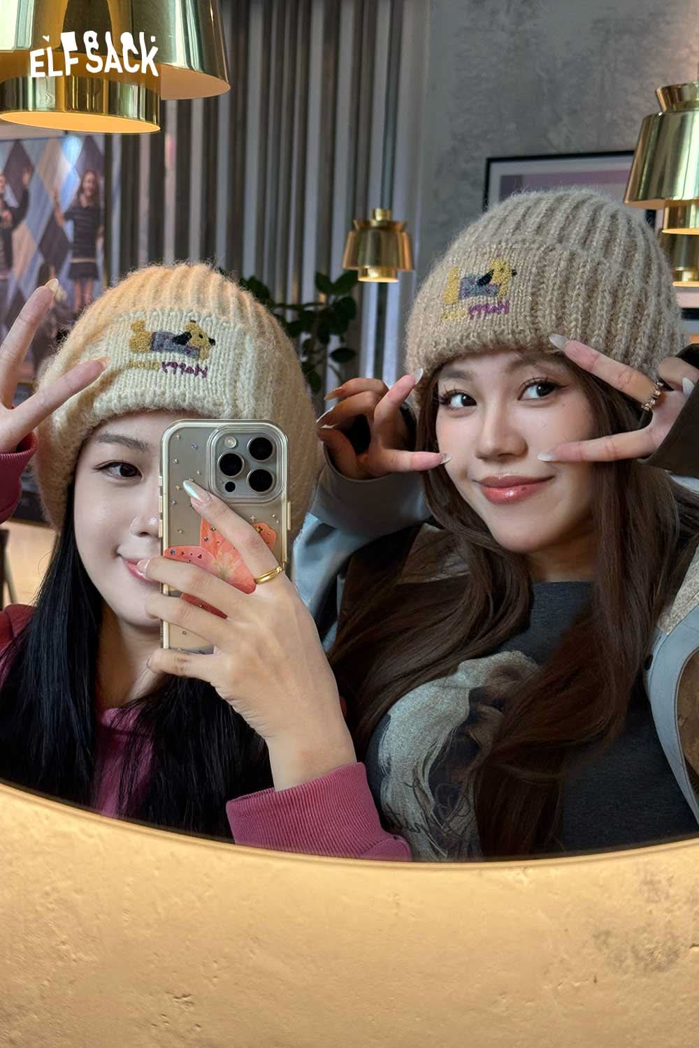 Two friends wearing a soft dog embroidered hat in a cozy indoor setting