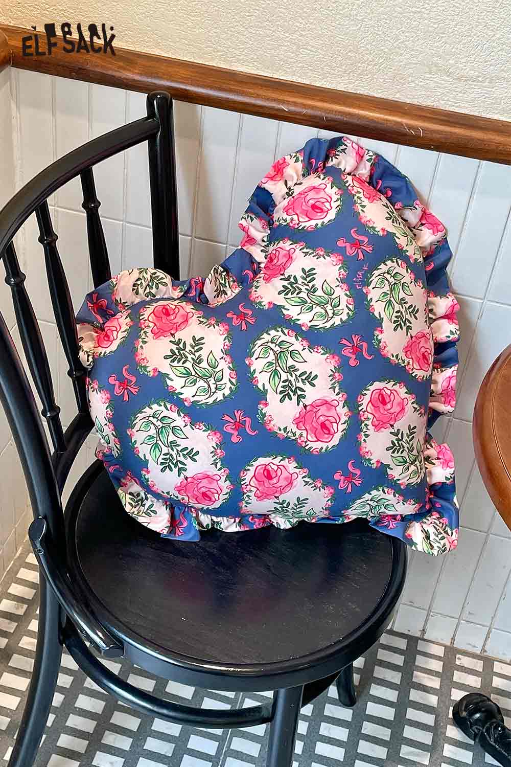 ELFSACK heart shaped rose pillow with navy floral print and ruffle trim on black wooden chair