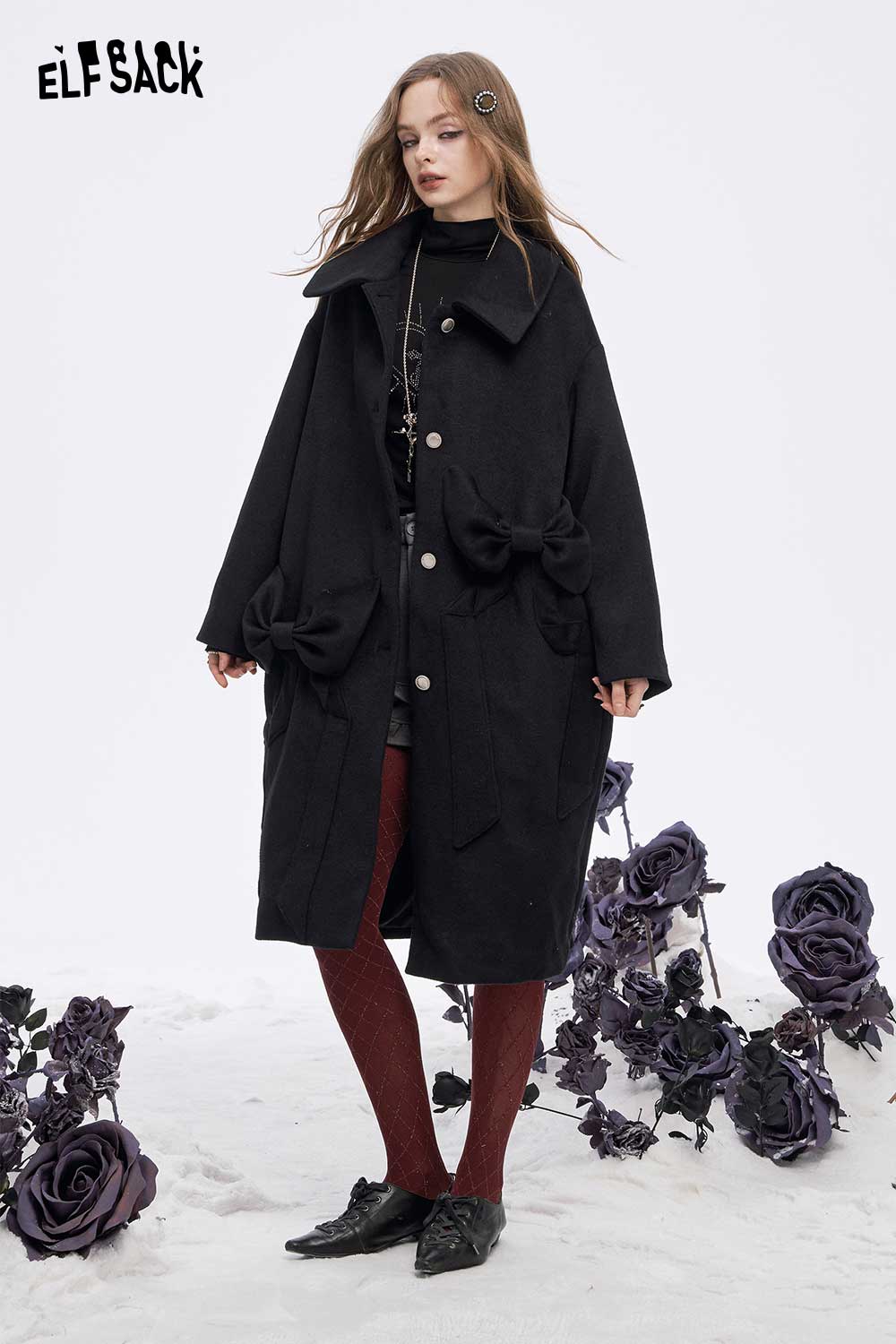 ELFSACK soft slimming high neck tshirt layered under a stylish coat with a black floral background