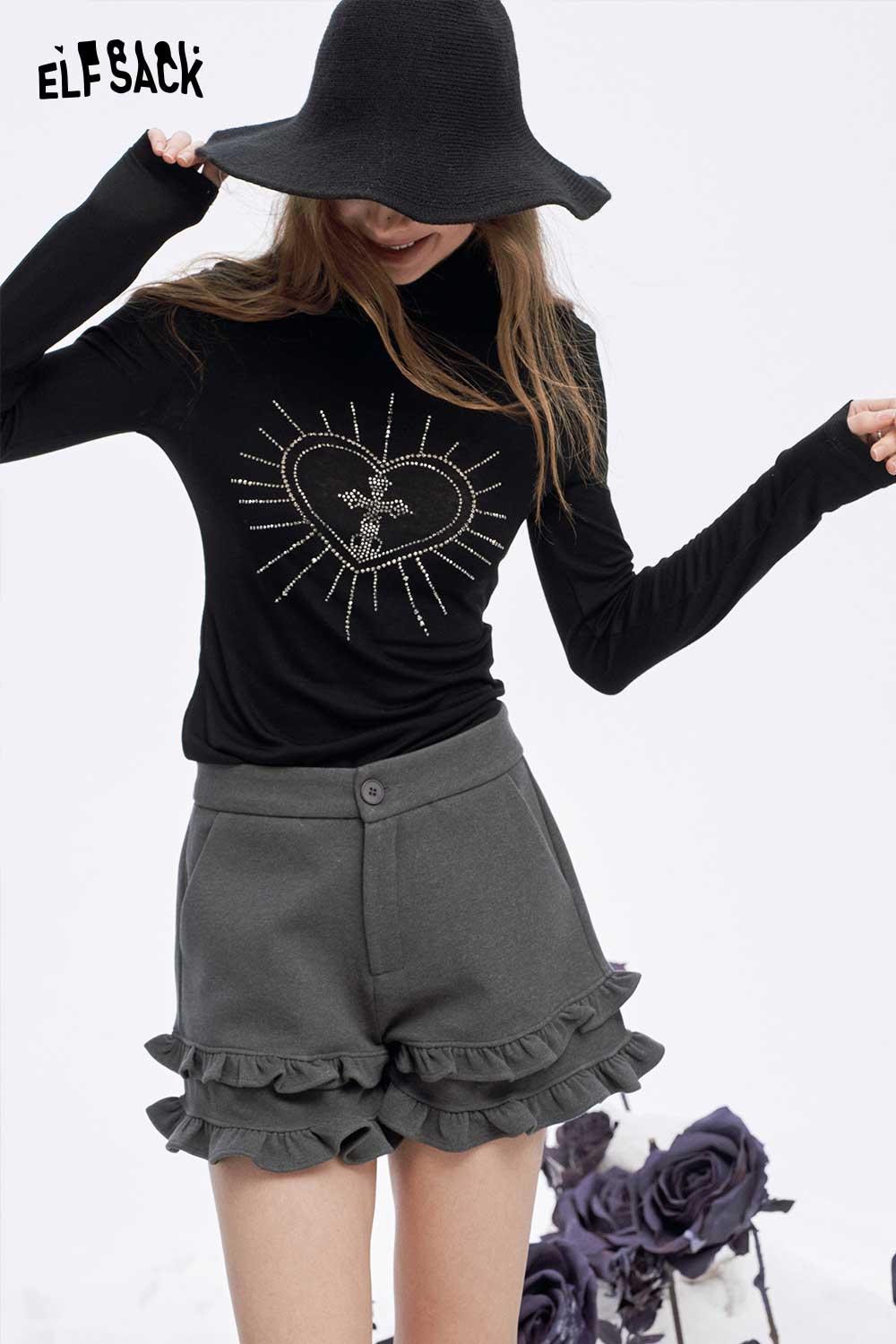 Model wearing a soft slimming high neck tshirt featuring a heart design and ruffled shorts