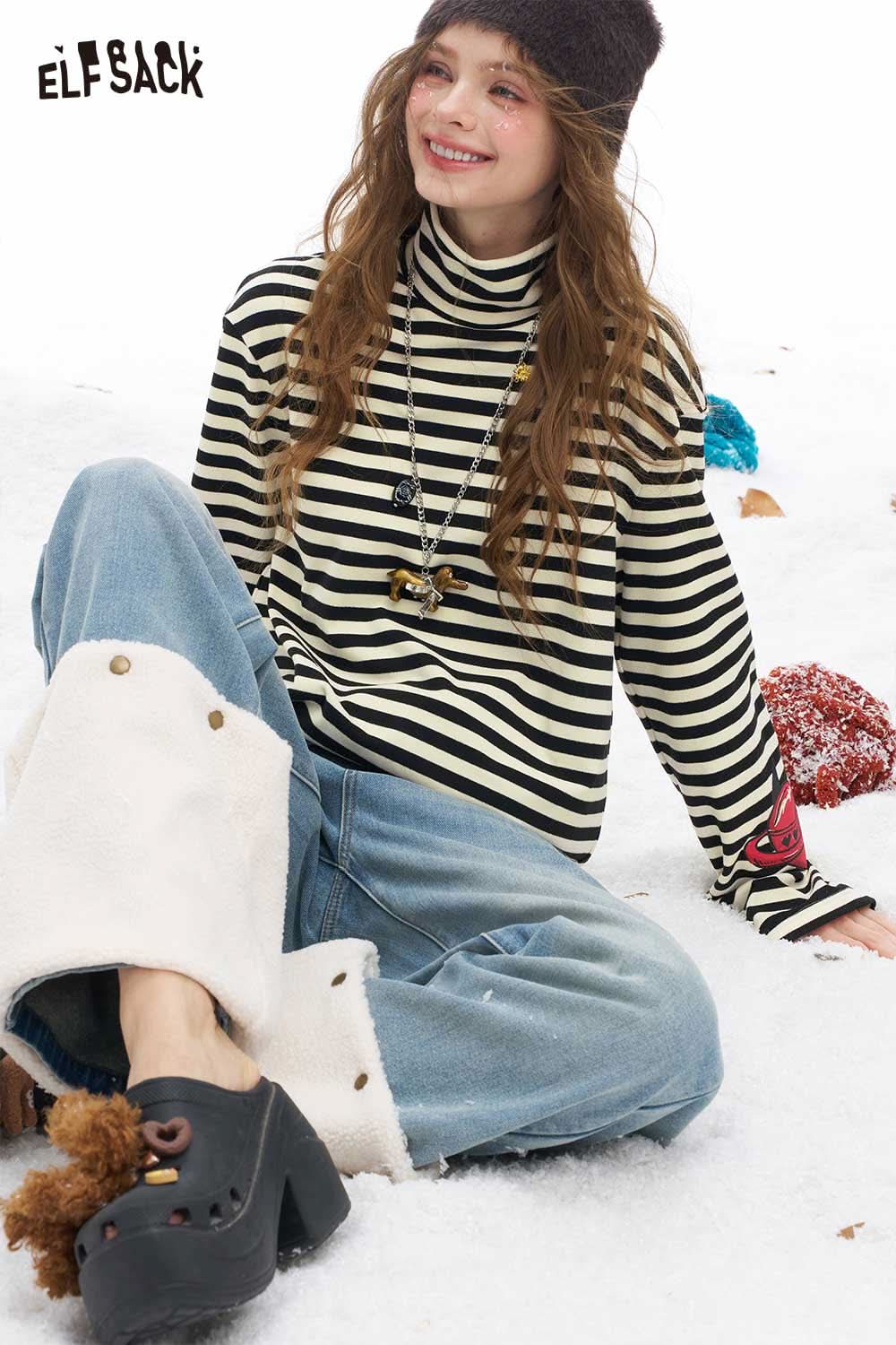 ELFSACK striped high neck graphic t-shirt for women styled with relaxed jeans in snowy setting
