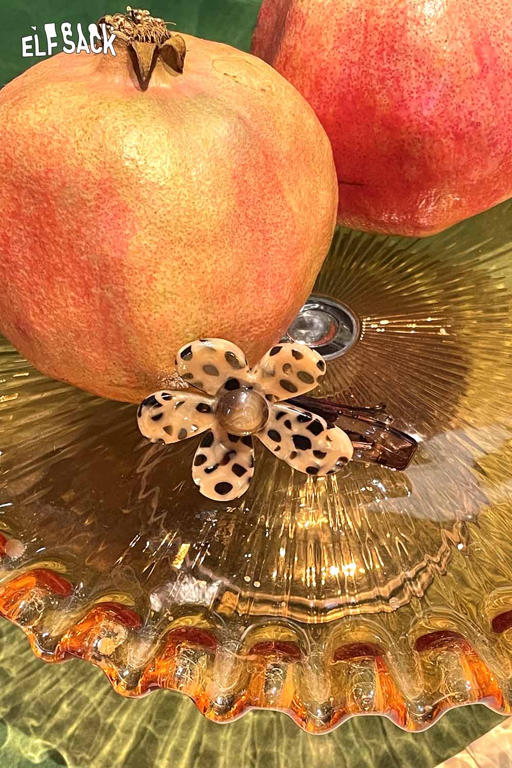 ELFSACK tortoise shell floral hairpin on a decorative plate with pomegranates