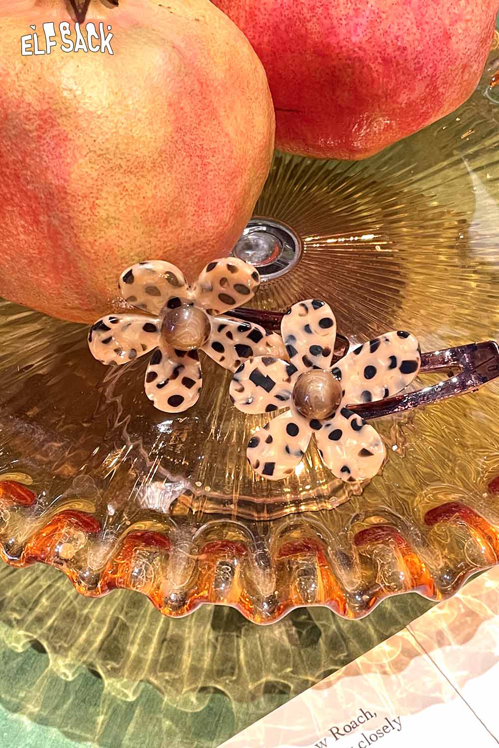 ELFSACK tortoise shell floral hairpin with leopard print design on a decorative glass serving plate