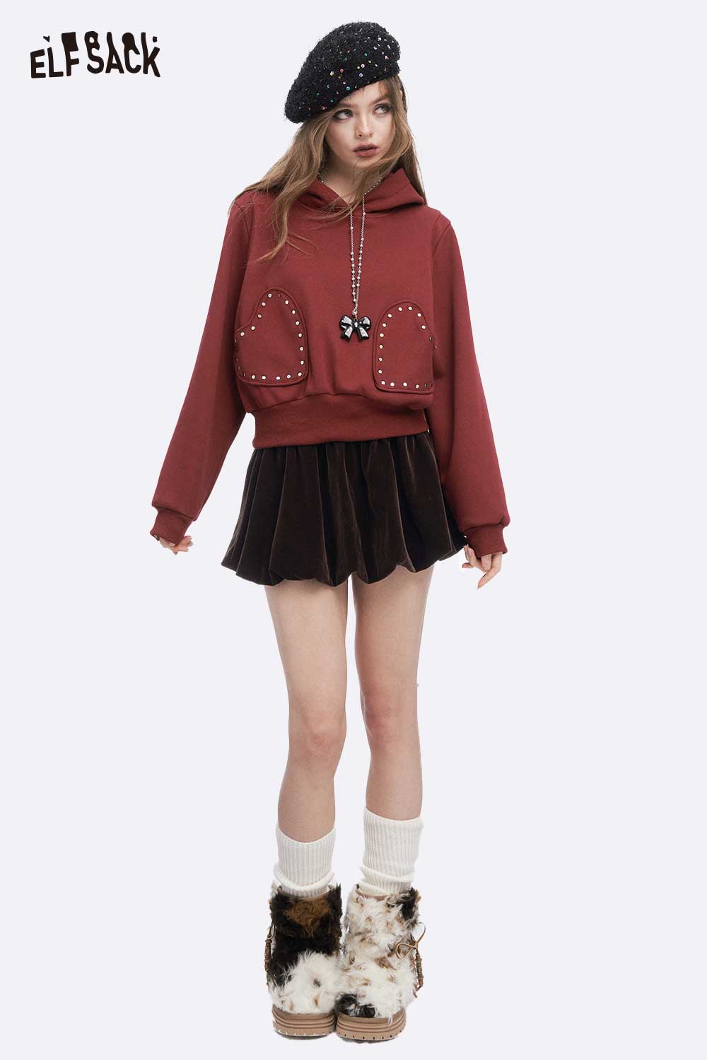 Stylish model wearing a burgundy hoodie with a velvet short skirt for women and trendy accessories