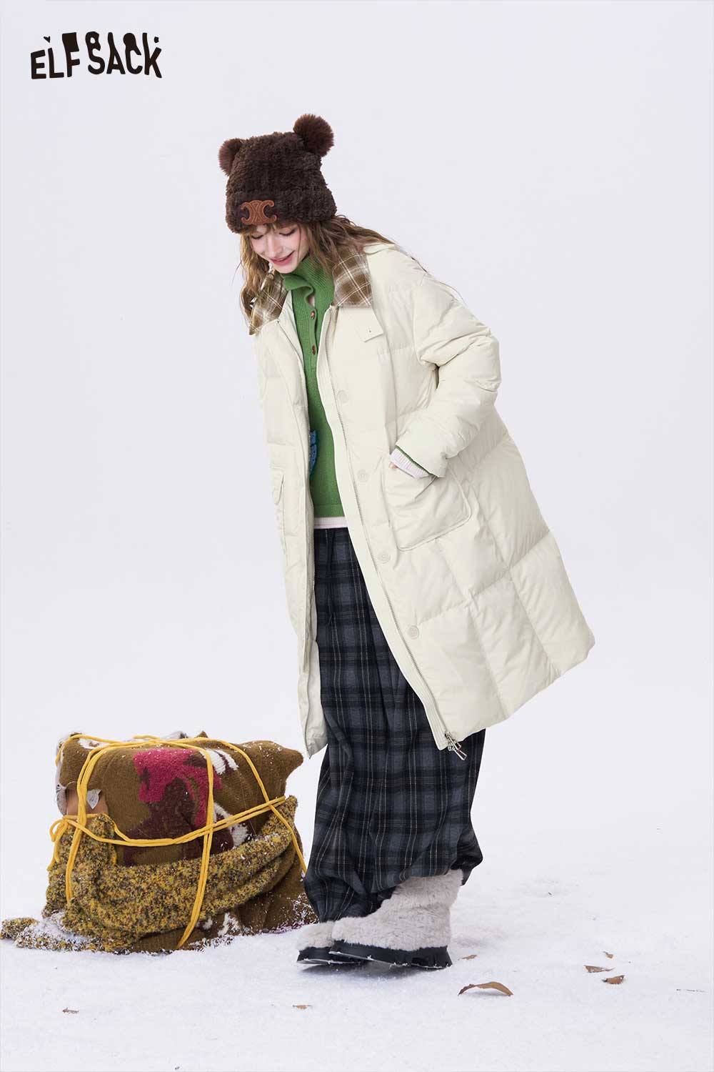 ELFSACK minimalist long down coat for women in cream, styled with a green hoodie and patterned skirt
