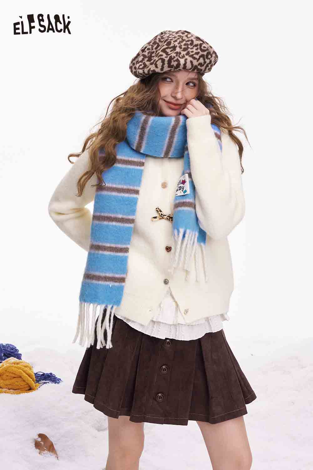 ELFSACK preppy striped fringe scarf in blue and white paired with a cozy sweater and skirt