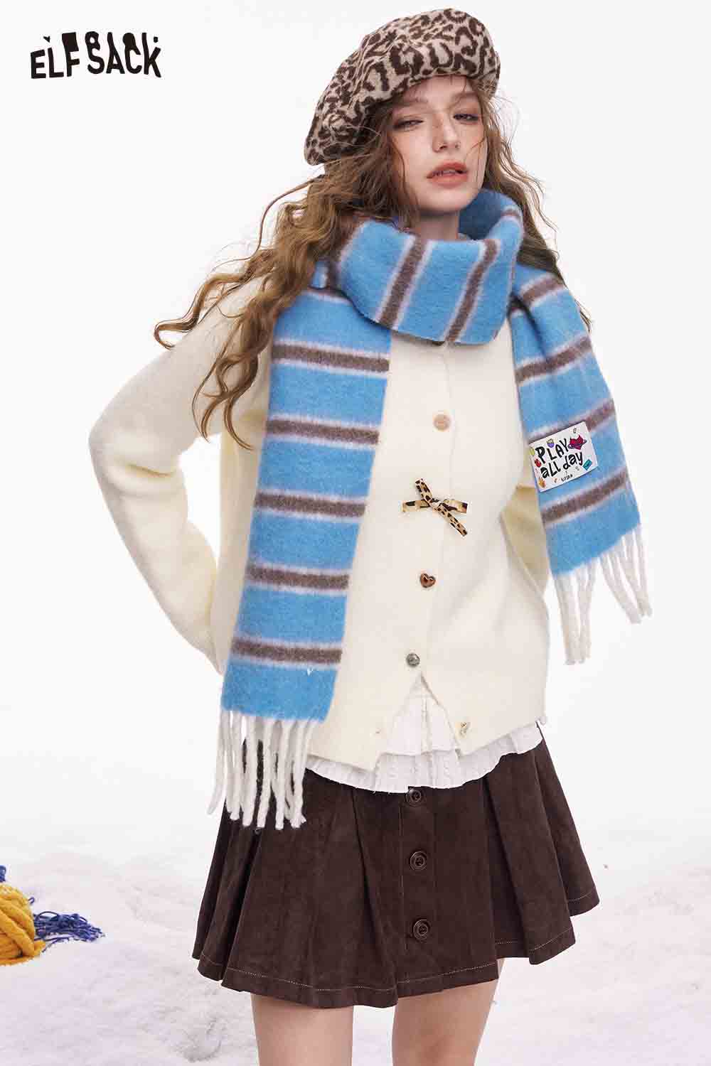 Fashionable model wearing a preppy striped fringe scarf styled with a cozy sweater and beret