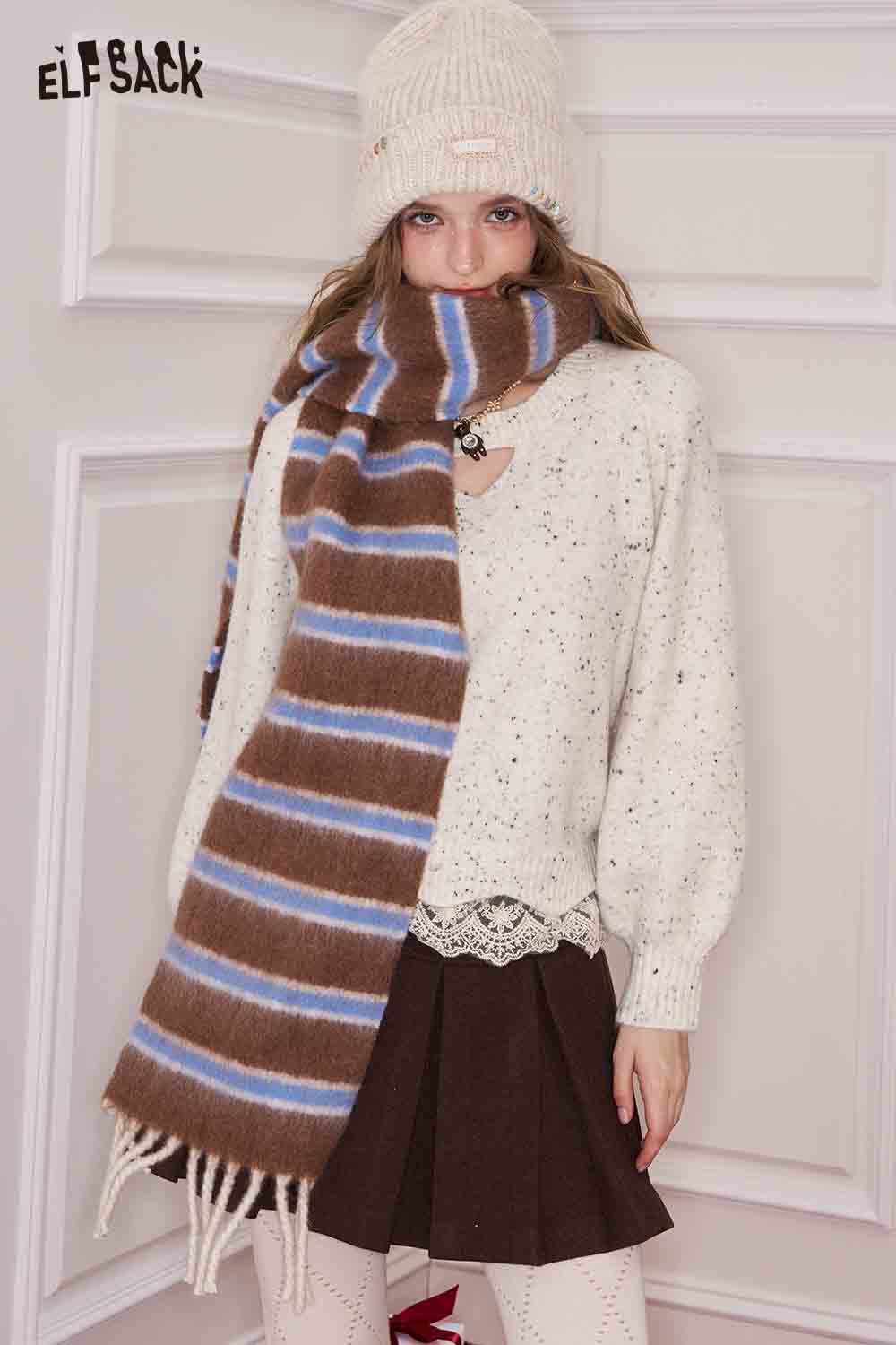 ELFSACK preppy striped fringe scarf in brown and blue, styled with a cozy outfit and winter hat