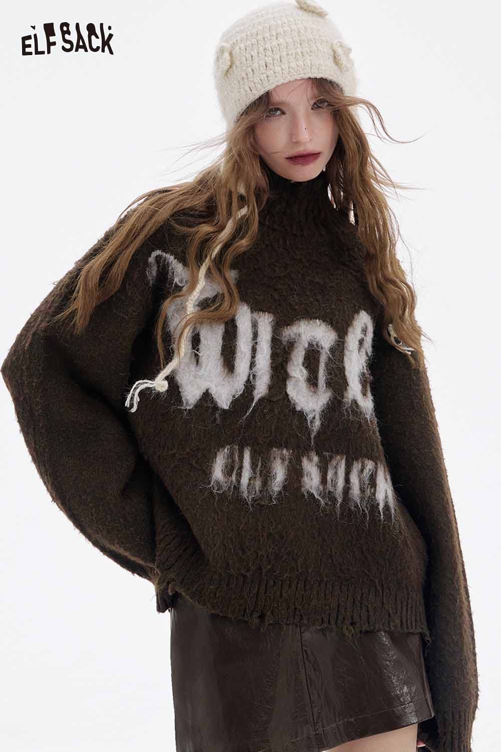 ELFSACK model wearing a soft shiny leather skirt paired with an oversized sweater and a knitted hat